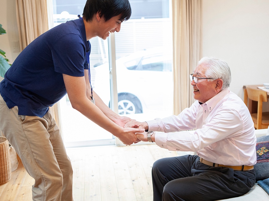 高齢男性を介助する男性看護師