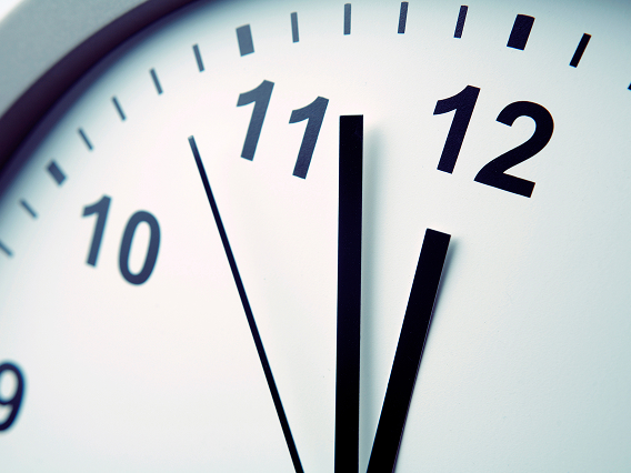 まもなく深夜0時を指す壁掛けの時計